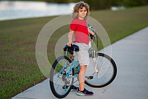 Sporty kid riding bike on a park. Child riding bicycle. Kid learns to ride a bike. Kids on bicycle. Happy child in t