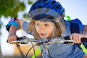 Sporty kid riding bike on a park. Child in safety helmet riding bicycle. Kid learns to ride a bike. Kids on bicycle