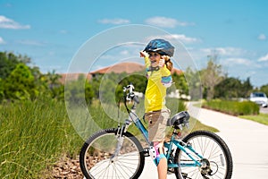Sporty kid riding bike on a park. Child in safety helmet riding bicycle. Kid learns to ride a bike. Kids on bicycle