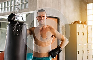 Sporty man boxer relax after punching at a boxing gym,Strong men boxer training on punching bag