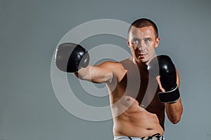 Sporty man during boxing exercise making direct hit