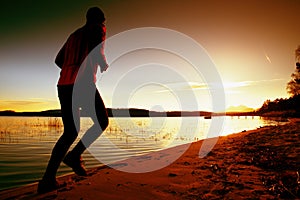 Sporty Man doing Morning Jogging on Sea Beach at Bright Sunrise Silhouettes