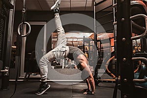 A sporty man in the gym is doing Yoga exercises. Sirsasana or Kapalasana, the position on the head.