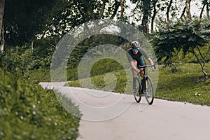 Sporty man in helmet and glasses riding bicycle outdoors