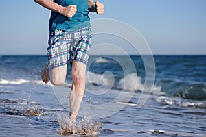 Sporty man during jogging on a evening beach