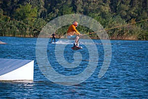 Sporty man is jumping on a wakeboard