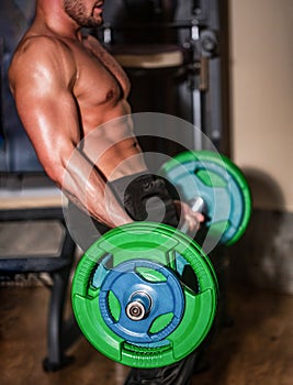 Sporty man lifts barbell in gym. Close up training with barbell. Man lifting barbells working out in gym. Workout at the