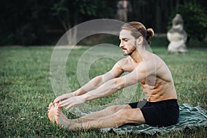Sporty man practicing yoga outdoor