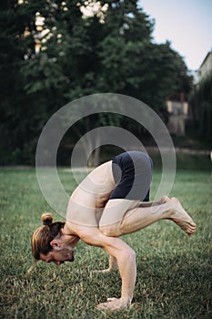 Sporty man practicing yoga outdoor