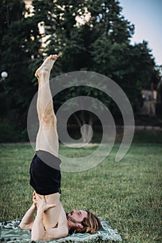 Sporty man practicing yoga outdoor