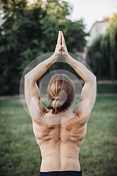 Sporty man practicing yoga outdoor