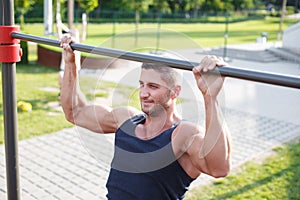 Sporty man pull-up outdoor