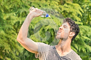 Sporty man refreshing with cold water after run training