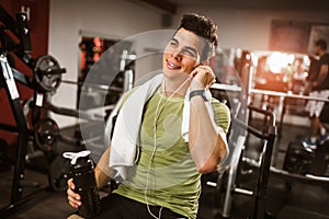 Sporty man resting, having break drinking water after doing exercise