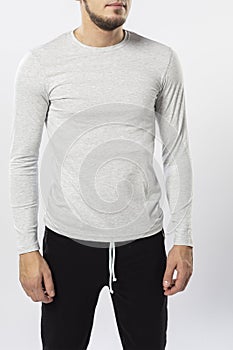 sporty man in sweatpants and long sleeve t-shirt on white background