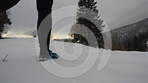 Sporty man walking on a snowed mountain in winter