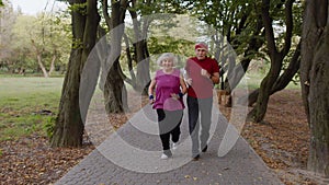 Sporty mature couple family jogging together. Senior husband and wife doing cardio workout exercises