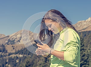 Sporty millenial texting her hiking achievements.