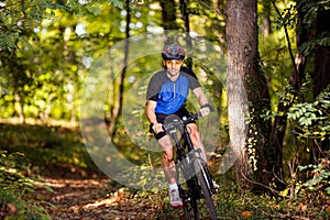 Sporty Mountainbiker man practicing mountain biking in forest