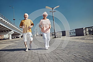 Sporty pensioners working out on the river bank