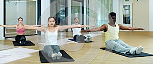 Sporty people doing stretching workout during pilates training photo