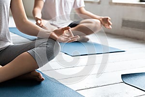 Sporty people practicing yoga at group lesson, doing Sukhasana exercise