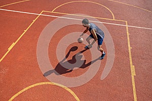Sporty player guy training basketball at outdoor court.