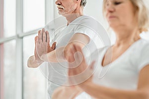 Sporty senior couple doing breathing exercise in yoga class.Health concept