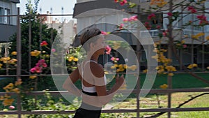 Sporty sexy woman running, exercising outdoors at sunrise. Sun lens flare glare, healthy active lifestyle, back view