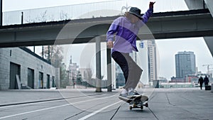 Sporty skater making trick on board outdoor. Skateboard rolling on asphalt.