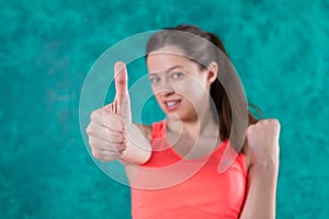 Sporty smiling girl shows gesture thumb up