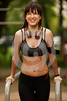 Sporty smiling woman doing strength training for arms