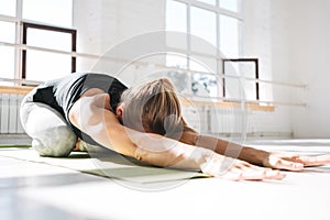 Sporty strong woman doing practicing yoga fitness mat in sunny gum
