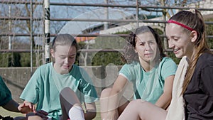 Sporty teenaged girls having rest after successful training