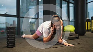 Sporty woman in activewear doing stretching exercise in gym