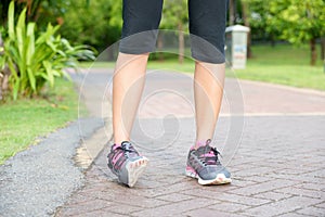 Sporty woman ankle sprain while jogging or running at park.