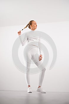 Sporty woman in athleisure against white background photo