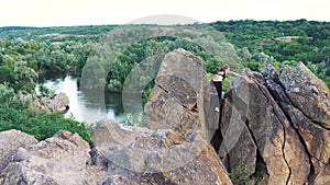 Sporty woman climbing on mountain cliff with beautiful landscape ob background. Healthy lifestyle. active extreme.