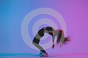 Sporty woman dancing in studio against colorful phantom blue color background