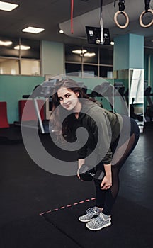 Sporty woman does the exercises with dumbbells