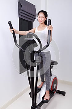 Sporty woman doing exercises with elliptical trainer