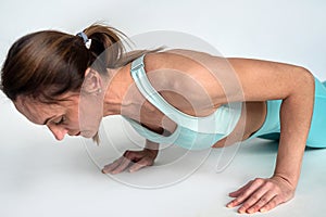 sporty woman doing push-ups in the gym on a white background.