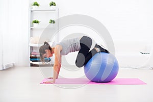 Sporty woman doing stretching fitness exercise on ball