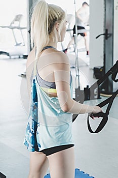 Sporty woman doing TRX exercises in the gym - Image