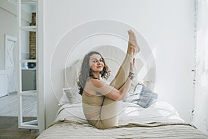 A sporty woman doing yoga, performing the Paripurna Navasana exercise, balance pose, at home or in a yoga studio with