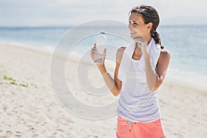 sporty woman drinking mineral water after workout for refreshment