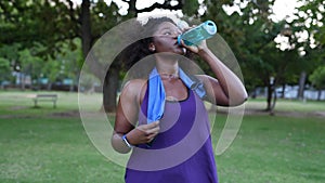 Sporty woman drinking water after exercise