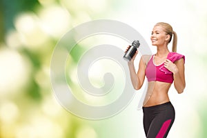 Sporty woman drinking water from sportsman bottle