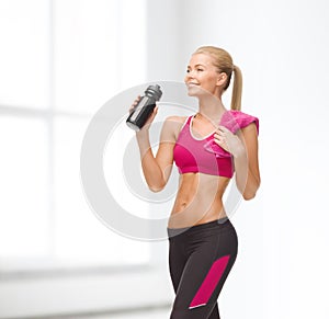 Sporty woman drinking water from sportsman bottle