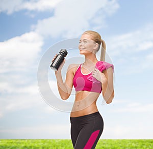 Sporty woman drinking water from sportsman bottle